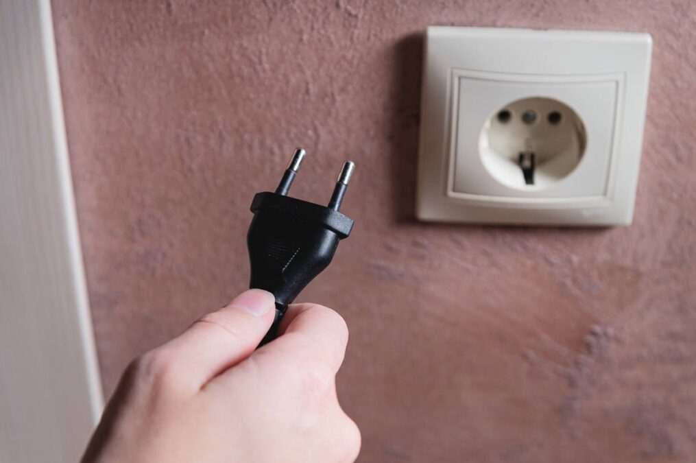 pessoa tirando aparelho da tomada energia